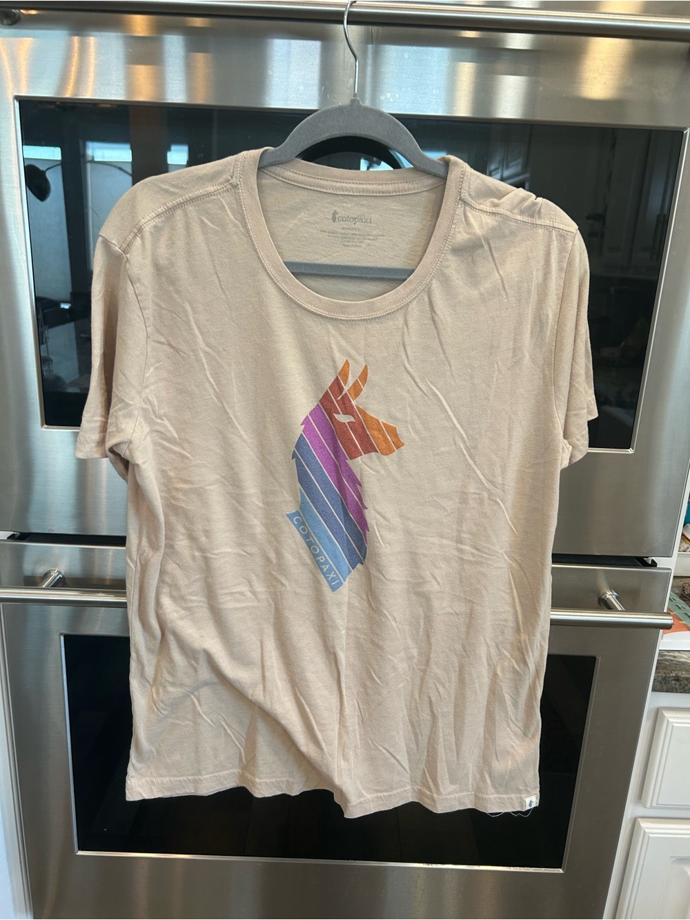 cotopaxi Tan Short Sleeve Tee with Rainbow Stripe Llama L has wear loose threads